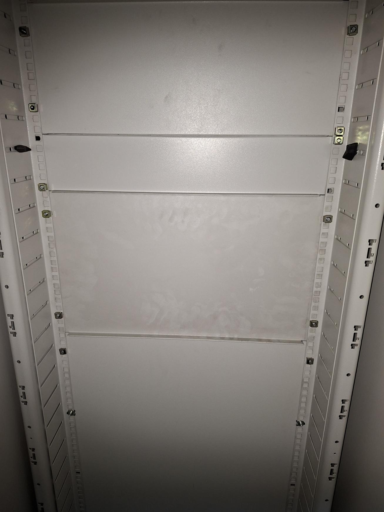 Black dust contamination on a Data Hall cabinet blanking panel despite meeting ISO 14644-1 Class 8 airborne particulate limits.